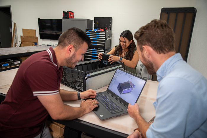 The RackSolutions team gathered around a laptop