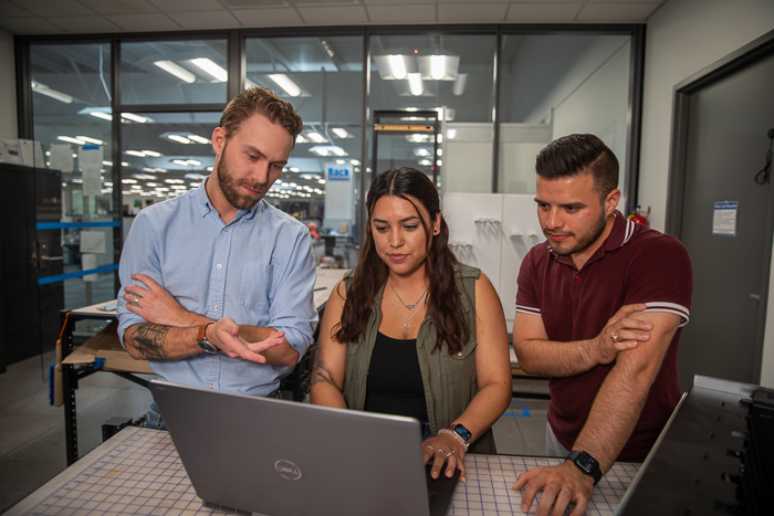 Three RackSolutions team members working together at a laptop