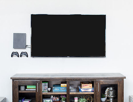Xbox One X Mounted Behind Television